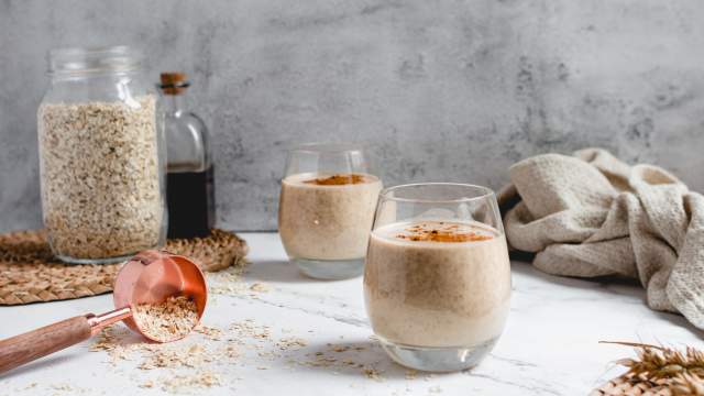 Creamy banana oatmeal smoothie with bananas, oats, almond milk, and almond butter blended and served in two glasses.