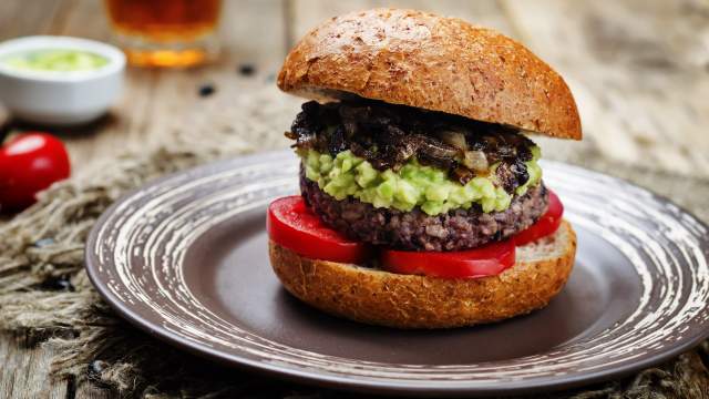 Salsa Black bean burgers with avocado, tomatoes, and onions on a bun. 