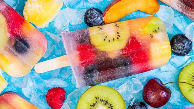 Fresh fruit popsicles made with kiwi, raspberries, peaches, cherries, blueberries, and coconut water.