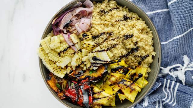 Balsamic grilled vegetables with peppers, summer squash, corn, and onions with quinoa in a bowl.