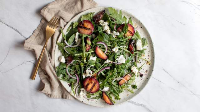 Grilled plum salad with arugula, grilled plums, red onions, goat cheese, and fresh herbs. 