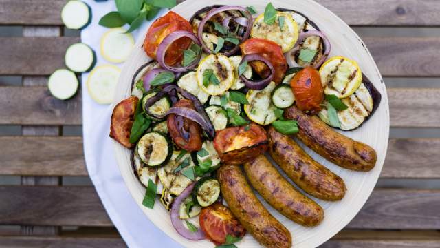 Grilled chicken sausage with vegetables on a plate.