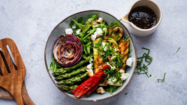 Grilled vegetabe salad with zucchini, asparagus, mushrooms, peppers, onions, and feta cheese served over arugula.