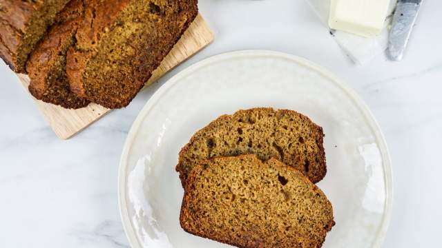 Healthy Cinnamon Banana Bread sliced on a plate with the whole loaf on the side.