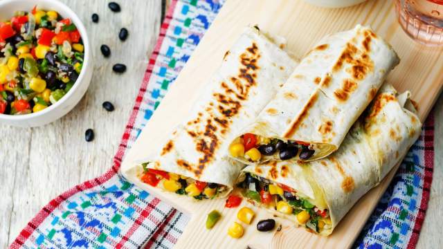 Homemade frozen burritos with beans, rice, and vegetables on a plate.