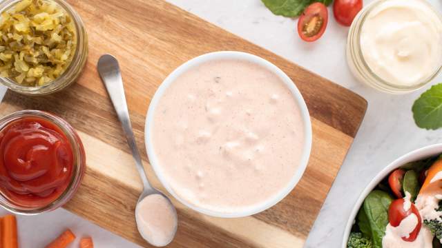 Healthy Thousand Island dressing in a bowl with ketchip, yogurt, relish, and salad on the side.