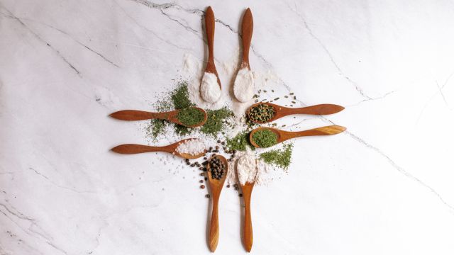 Homemade ranch seasoning in small wooden spoons with dried herbs, buttermilk powder, salt, and pepper.