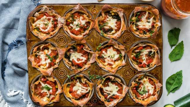 Lasagna cupcakes with ricotta cheese, vegetables, and mozzarella cheese baked in a muffin tin with marinara sauce.