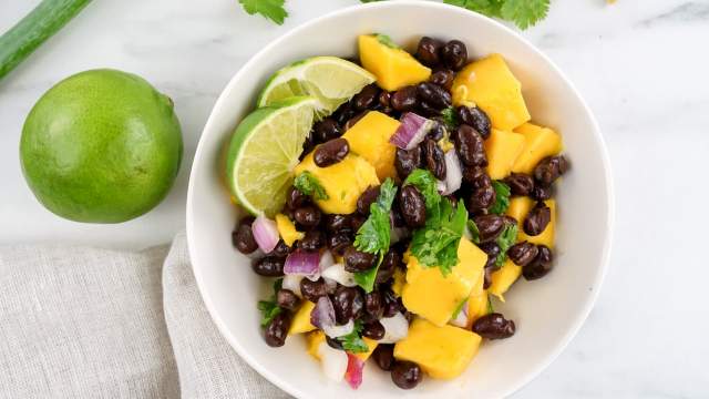 Mango salsa with fresh mango, black bans, red onion, cilantro, and lime juice in a bowl.