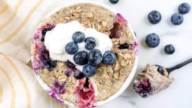 Microwave blueberry muffin in a ramekin with blueberries, yogurt, and walnuts.