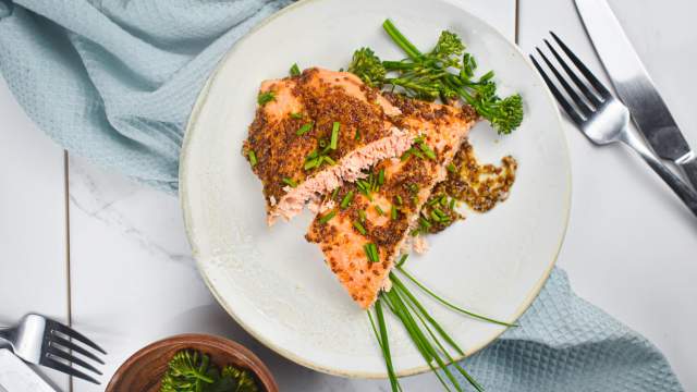 Mustard and maple glazed salmon with a honey mustard style sauce on a plate with broccolinl.