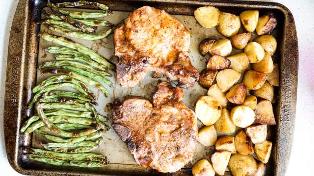 Sheet Pan Pork Chops with potatoes and green beans on a sheet pan.