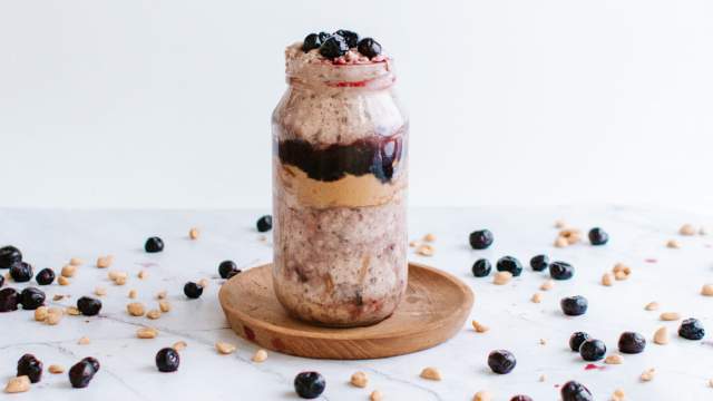 PBJ overnight oats in a mason jar with a layer of grape jelly and peanut butter. 