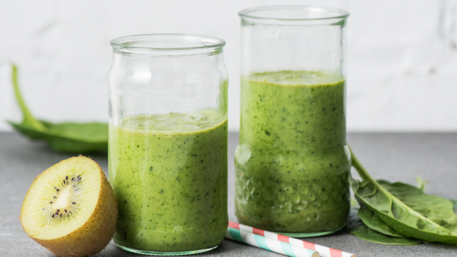 Pineapple cucumber smoothie with bananas, spinach, cucumber, and pineapple blended and served in two glasses.