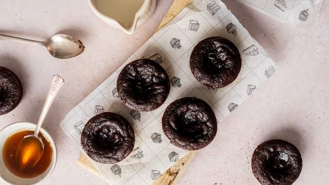 Flourless Pumpkin Brownie Bites with canned pumpkin and almond butter on a wooden cutting board with maple syrup on the side.