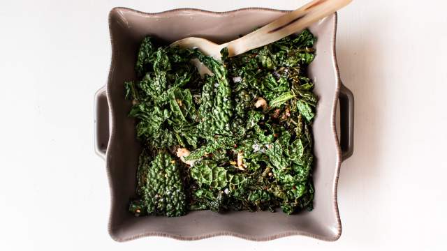 Sauteed kale with garlic, red wine vinegar, salt, and pepper in a ceramic dish.