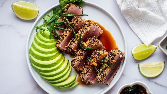 Sesame crusted tuna sliced and cooked rare served with soy dipping sauce and avocado.