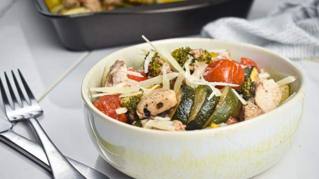 Italian chicken and vegetables in a bowl with Parmesan cheese.