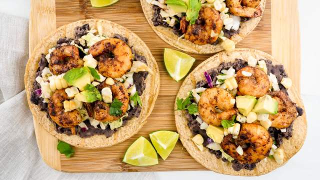 Shrimp tostadas with black beans, cabbage, spiced shrimp, avocado, and corn on baked tortillas.