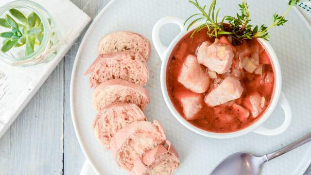 Fish stew with red snapper, carrots, onions, celery root, and herbs in a tomato broth with bread on the side.