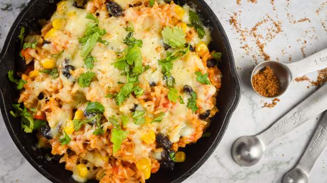 Mexican brown rice casserole with black beans, corn, tomatoes, bell peppers, and spices.