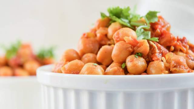 Slow Cooker Chana Masala in a bowl with chickpeas in a curry tomato sauce.