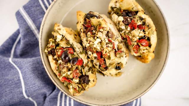 Skow Cooker Greek Chicken Breats stuffed with feta, olives, spinach, red peppers, and artichoke hearts.