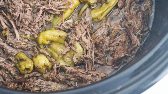 Slow cooker pepperoncini beef in a slow cooker with shredded beef and jarred pepperoncinis.