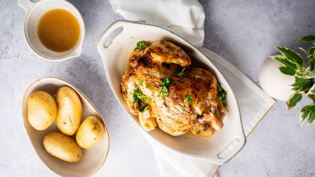 Slow cooker rotisserie chicken with a homemade spice rub, lemon, and parsley with potatoes on the side.