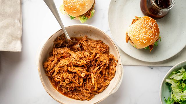 Slow cooker spicy pulled pork with shredded pork tenderloin in spicy barbecue sauce in a bowl.