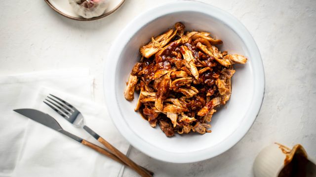 Slow cooker sweet and spicy chicken with soy sauce, Asian chili paste, and ginger in a bowl.