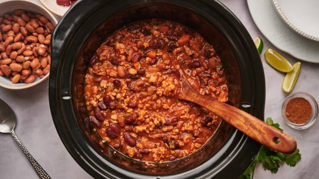 Slow cooker turkey chili with ground turkey, pinto beans, kidney beans, and tomatoes in a slow cooker.