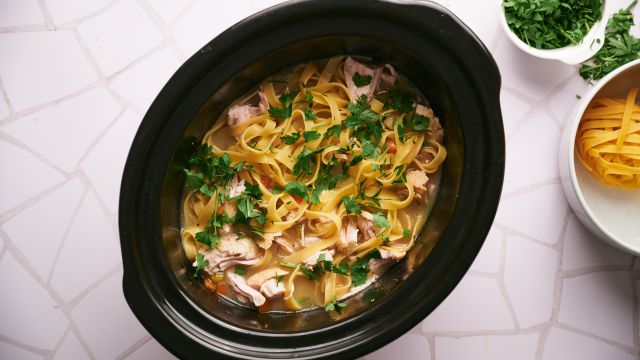 Slow cooker turkey soup with shredded turkey breast, egg noodles, carrots, celery, and onions.