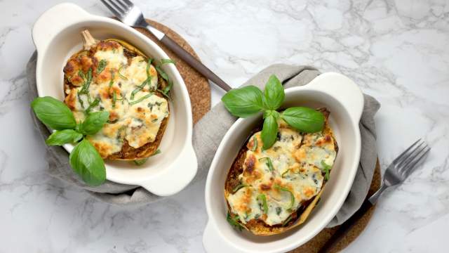 Spaghetti squash lasagna boats in two casserole dishes with basil.