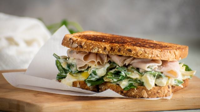 Spinach and artichoke grilled cheese sandwich with turkey breast on sliced wheat bread. 