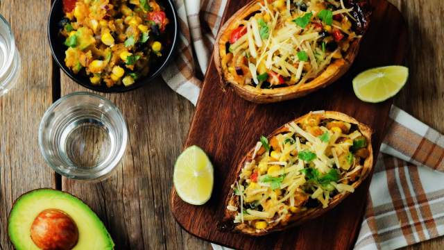 Stuffed sweet potatoes with Southwest ingredients including black beans, corn, diced tomatoes, green peppers, and cheese.