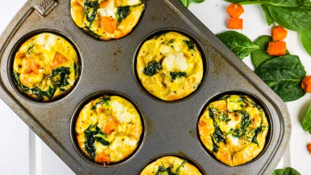 Sweet potato spinach egg muffin frittatas in a muffin tin with eggs, egg whites, spinach, and sweet potatoes.