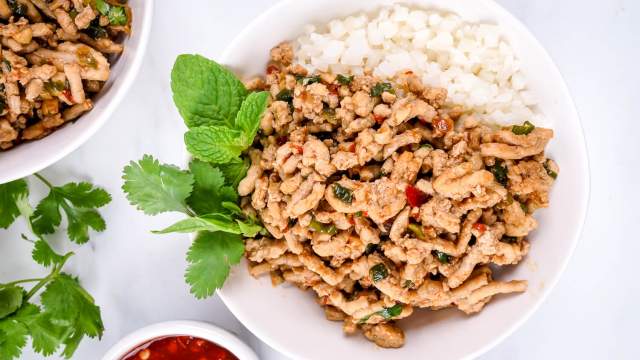 Thai Chicken Larb with fresh mint and basil in a white bowl with cauliflower rice.