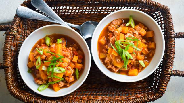 Turkey butternut squash chili with tomatoes, butternut squash, ground turkey, and sliced green onions.