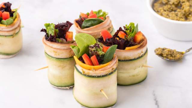 Low carb turkey pesto roll ups with thinly sliced cucumbers, deli turkey, cheese, pesto, and veggies.