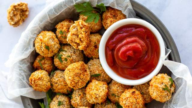 Vegetarian chickpea nuggets in a baking dish with fresh parsley and ketchup.