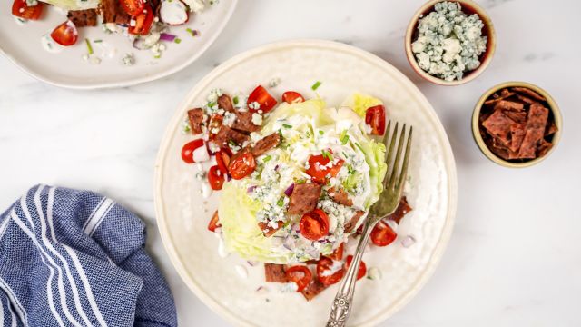 Classic wedge salad with creamy blue cheese dressing, tomatoes, red onions, and crispy bacon.